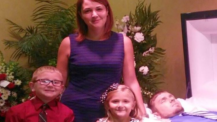Eva Holland posiert mit ihren Kindern am offenen Sarg ihres Mannes.