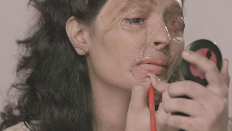 Reshma Bano Qureshi legt sich Lippenstift auf. Ihr Gesicht wurde bei einem Säureangriff entstellt.