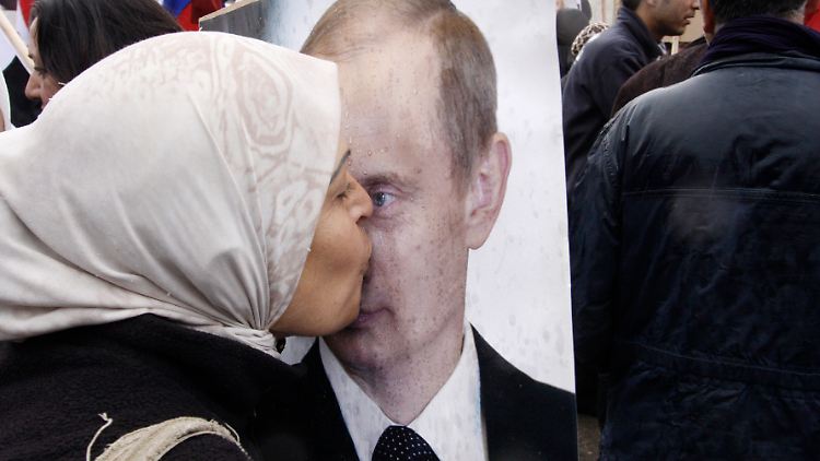 Eine Syrerin küsst auf einer Demonstration im Jahr 2012 ein Putin-Bild.