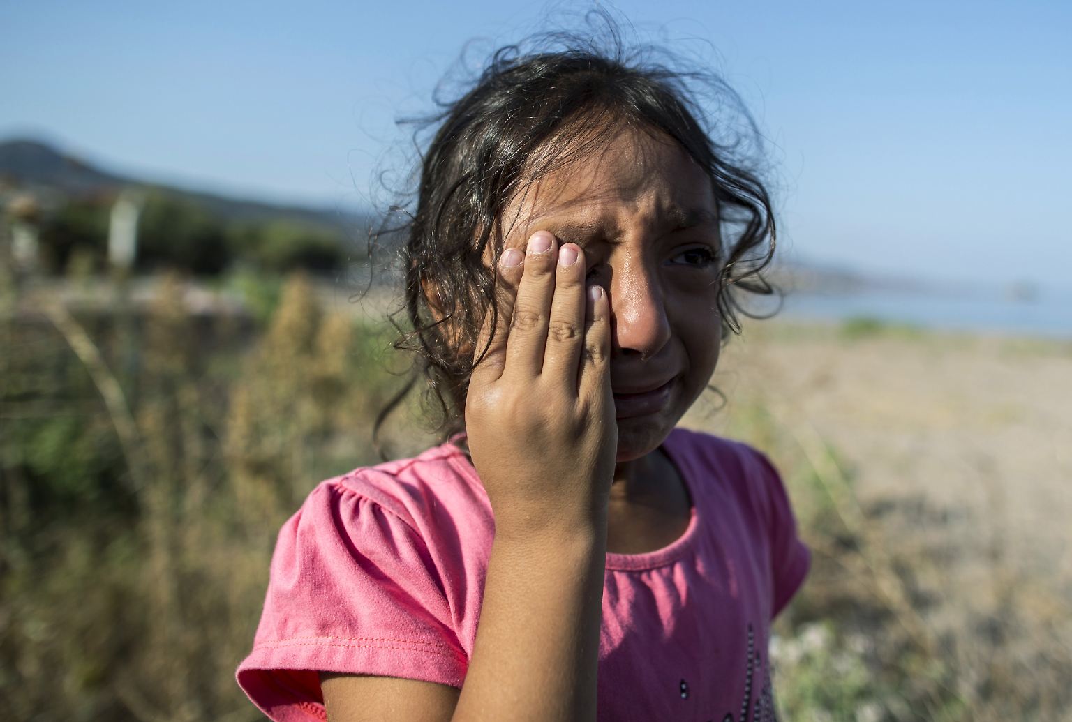 Die sechsjährige Yasmine bricht am Strand von Lesbos in Tränen aus. Die Männer, die ihre Familie von der Türkei aus mit einem Boot hierherbrachten, haben den wertvollsten Besitz des Mädchens über Bord geworfen: ein Kleid, das ihr ihre Großmutter geschenkt hatte.