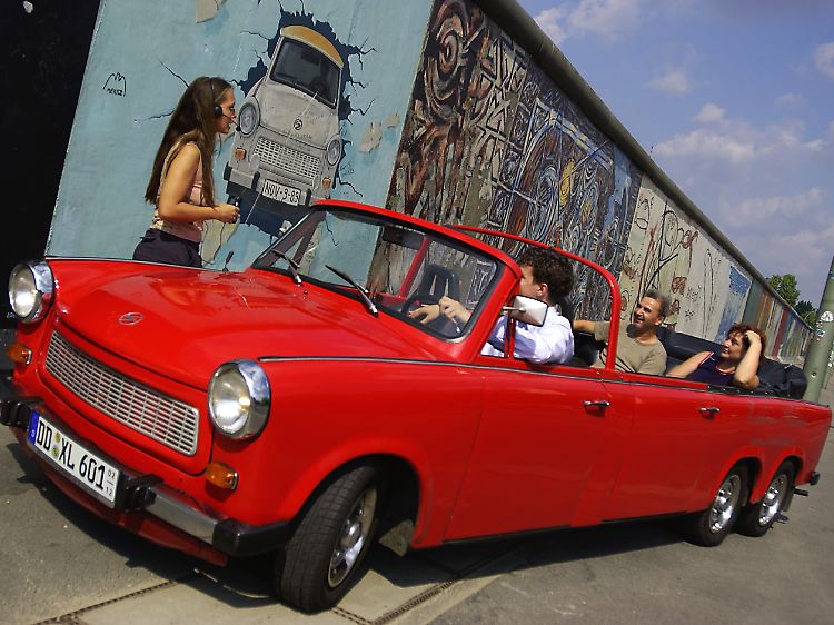 Eine knallrote Stretch-Version des "Trabant 601" während einer "Trabi-Safari" durch Berlin vor der "East Side Gallery", einem Teil der ehemaligen Berliner Mauer.