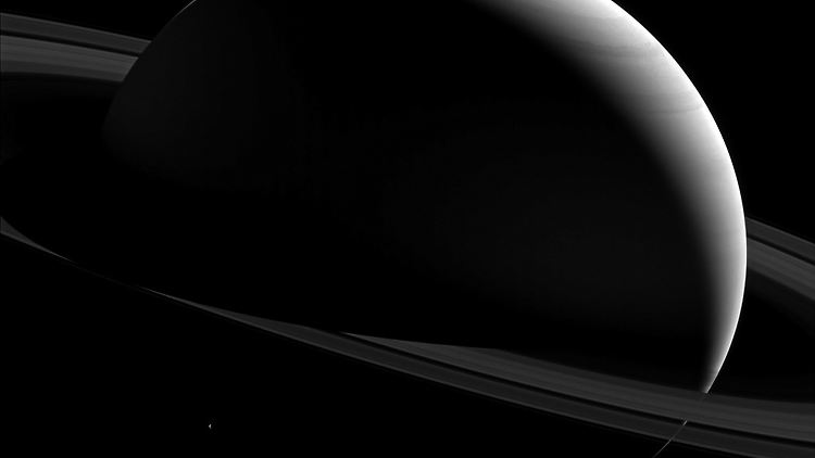 Saturn mit seinen typischen Ringen -  unten ist ganz winzig sein Mond Tethys zu erkennen.