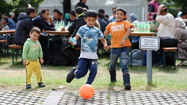Tausende Flüchtlingskinder werden eine Betreuung brauchen. Hier spielen drei von ihnen vor einem Zeltlager in München. 