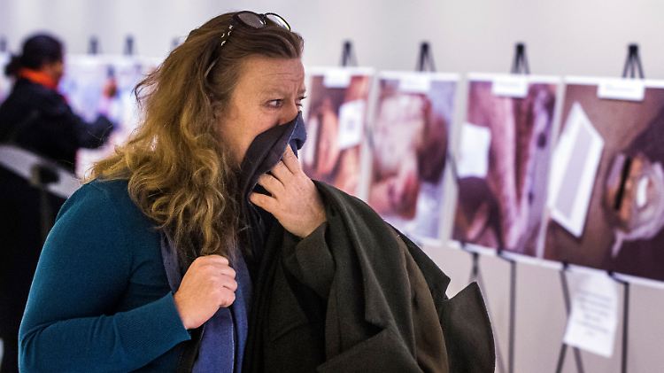 Eine Frau blickt bei einer Ausstellung fassungslos auf die Fotos des syrischen Fotografen namens "César": Die Bilder zeigen grausame Folterspuren.