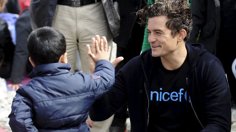 High Five: Orlando Bloom klatscht einen Jungen im Flüchtlingscamp Gevgelija ab.
