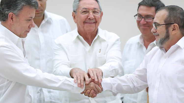 Kubas Präsident Raúl Castro (mi.) ist Zeuge des historischen Händedrucks zwischen Kolumbiens Präsident Juan Manuel Santos (li.) und dem Farc-Anführere Rodrigo Londono (r.)