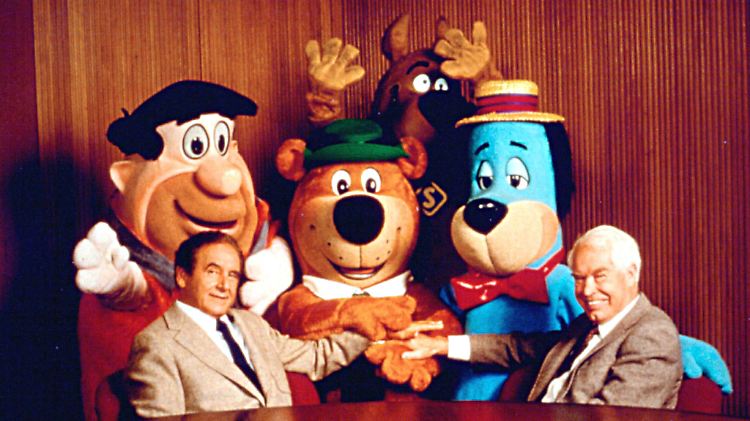 Joseph Barbera (l) und William Hanna mit ihren Geschöpfen, der Familie Feuerstein.