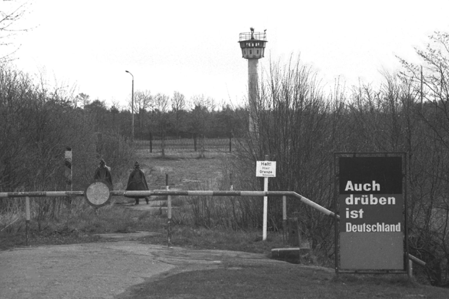 Eicholz nahe Lübeck, 1984: Mahnend steht das Schild vor dem Grenzstreifen mit Wachturm und erinnert mit anklagender Sachlichkeit daran, dass das Land hier eigentlich noch weitergeht. Auf der anderen Seite liegt Herrnburg in Mecklenburg-Vorpommern.
