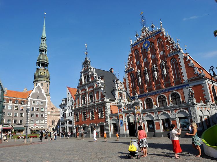 Das Schwarzhäupterhaus (rechts) und die Petrikirche (links) auf dem Rathausplatz der lettischen Hauptstadt Riga.