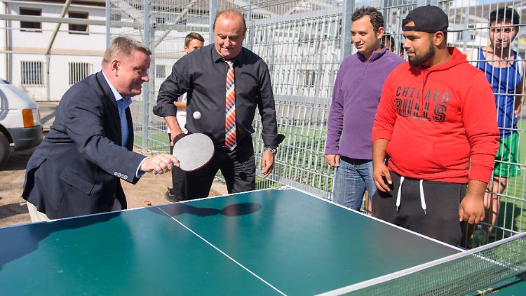 Klaus Bouillon (Mitte) beim Tischtennisspielen mit Flüchtlingen und Bundesgesundheitsminister Gröhe in der Erstaufnahmeeinrichtung in Lebach.