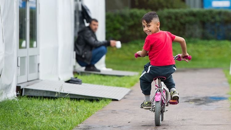 Flüchtlinge in Düsseldorf freuen sich über die milde Herbstluft.