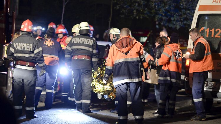 Nach der Explosion in einem Bukarester Nachtklub versorgen Feuerwehrleute Überlebende des Unglücks.