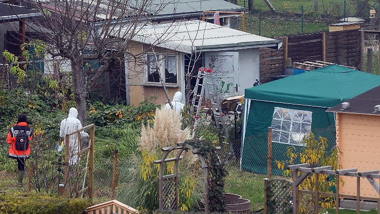 Polizisten suchen nach dem Geständnis in einem Schrebergarten in Luckenwalde nach weiteren Hinweisen zu den Taten.