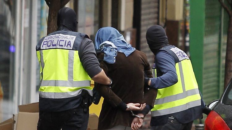 Einer der mutmaßlichen Terroristen wird von der Polizei in Madrid abgeführt.