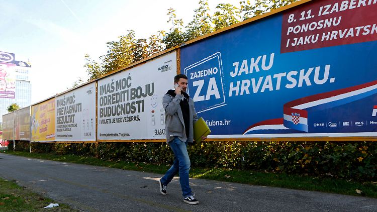 Ein Mann vor einem Wahlplakat der konservativen kroatischen HDZ. Am Sonntag wird ein neues Parlament gewählt.