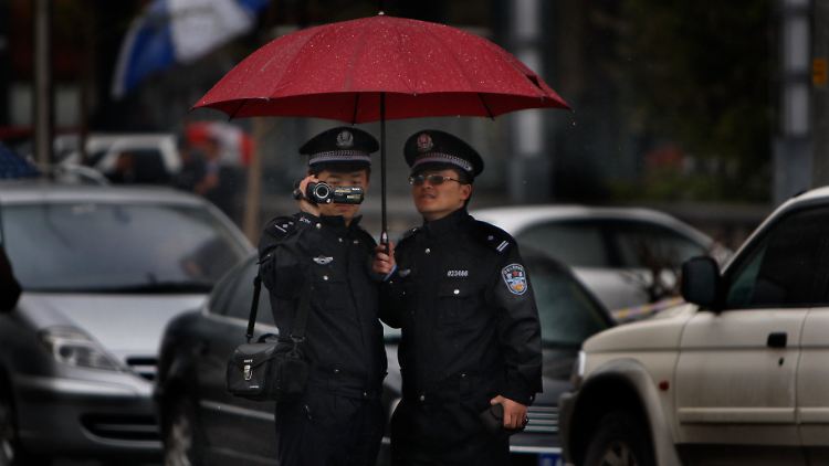 Chinesische Polizisten filmen Journalisten, die während eines Prozesses des Menschenrechtsanwalts Tang Jitian vor dem Gericht warten.