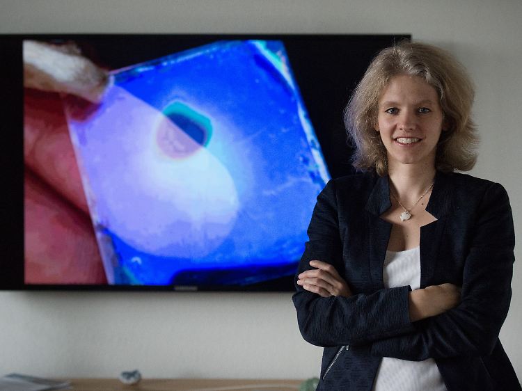 Bettina Lotsch vor einer Projektion, auf der eine Abbildung eines Prototyps eines Feuchtesensors zu sehen ist.