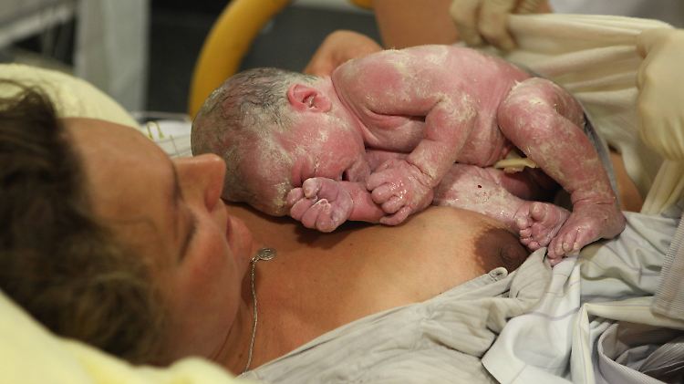 Neugeborenes Baby auf dem Bauch der Mutter.