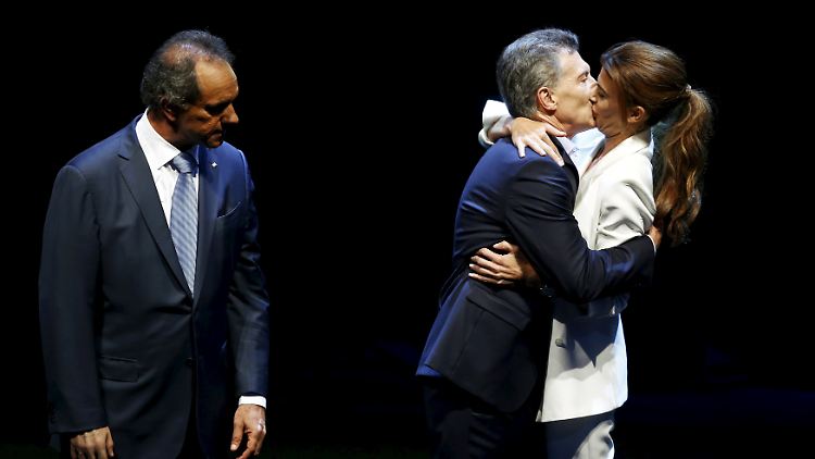Juliana Awada küsst Mauricio Macri - Daniel Scioli schaut zu.