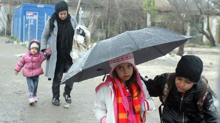 Zwei Kinder überqueren in strömendem Regen die serbisch-mazedonische Grenze.