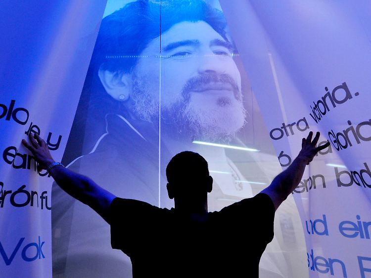 Ein Mann betrachtet die Fußball-Legende Maradona: Argentinien präsentiert sich in Frankfurt in einer Mischung aus Tradition, Multimedia und geschichtlichen Rückblicken.