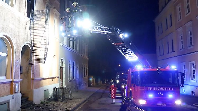 Einsatzkräfte der Feuerwehr sind nach dem Brand in einer geplanten Asylbewerberunterkunft in Meißen im Einsatz.