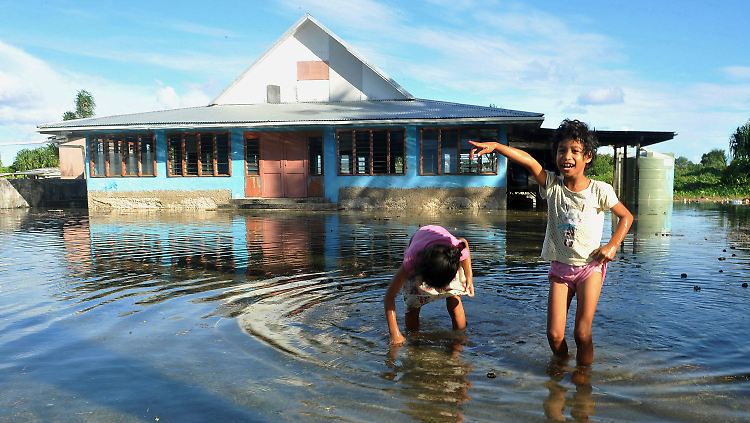 In Funafuti, der Hauptstadt von Tuvalu, spielen Kinder auf einem überfluteten Platz. Im Schnitt liegt der Inselstaat zwei Meter über dem Meeresboden.