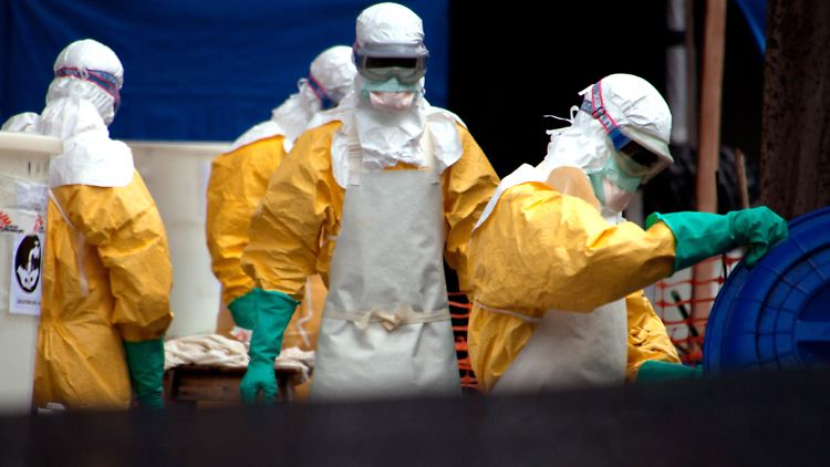 Mitarbeiter in Schutzanzügen reinigen den Patientenbereich in einem Ebola-Behandlungszentrum in Conakry (Guinea).