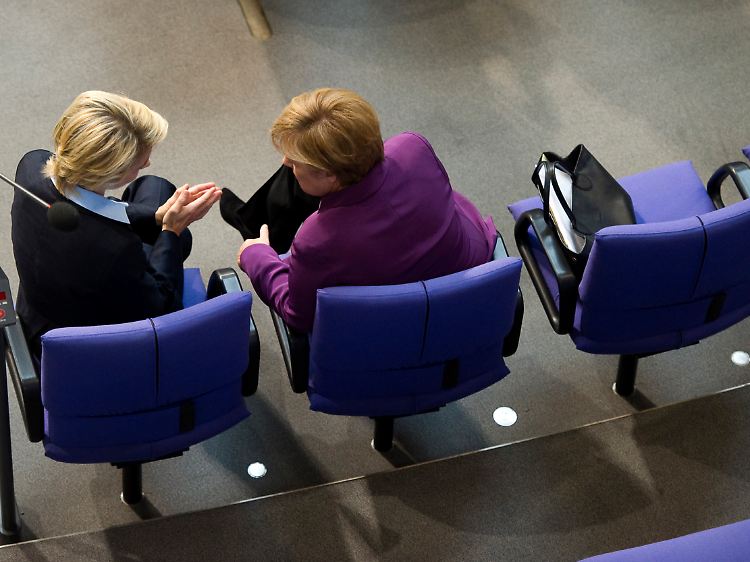 Arbeitsministerin von der Leyen und Bundeskanzlerin Merkel plaudern im Bundestag.