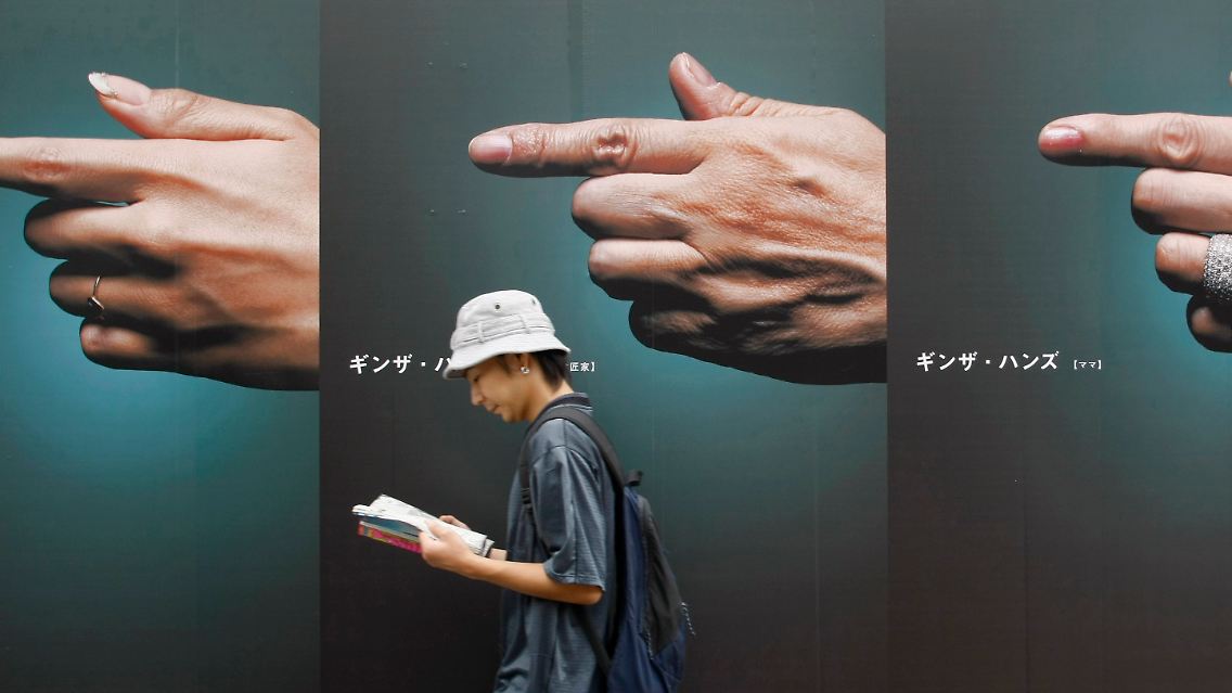Sinnbild für die Krise Japans: Ein Mann geht achtlos an Werbetafeln vorüber - dabei braucht das Land stärkeren Konsum.