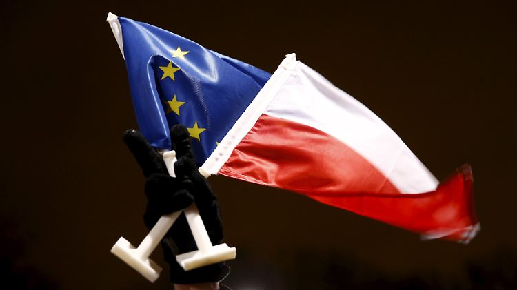 Ein Demonstrant in Warschau zeigt die Flagge Polens und der EU.