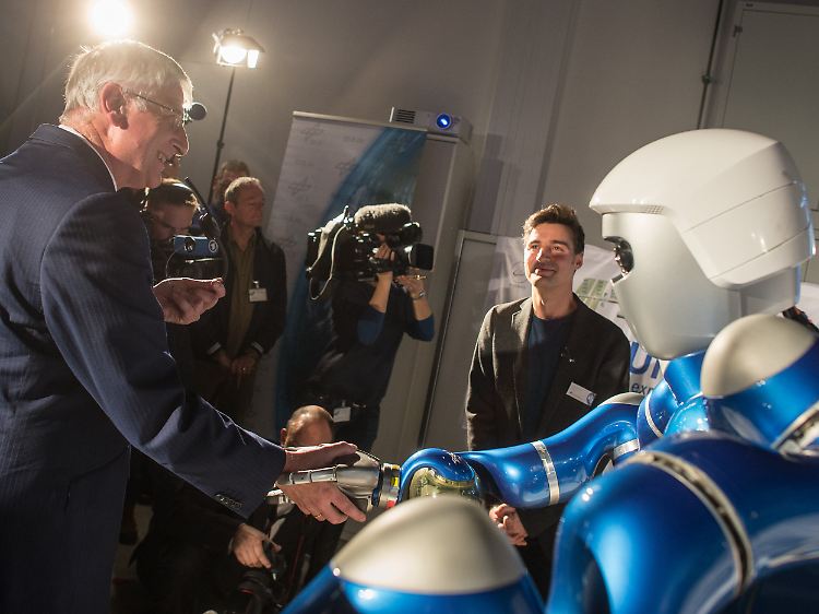 DLR-Vorstandsmitglied Dittus schüttelt Wolkow auf der ISS mittels des Roboters Justin virtuell die Hand.