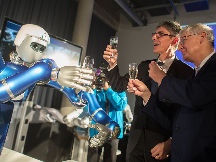 Albu-Schäffer (M) und Dittus (r.) prosten Wolkow auf der ISS, der den Roboter steuert, virtuell zu.