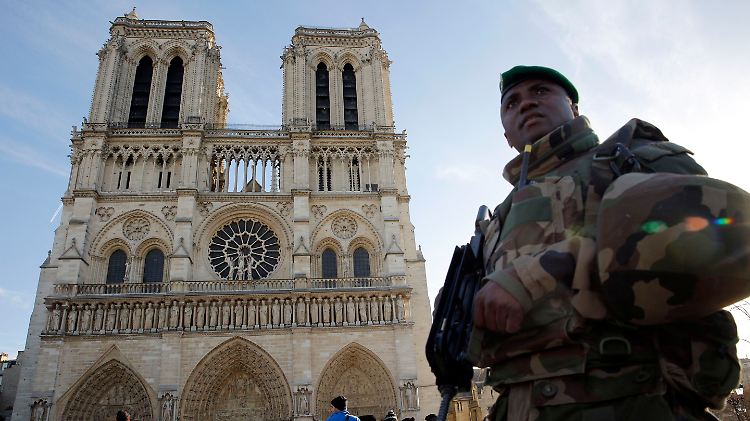 Schwer bewaffnete Soldaten patrouillieren vor der Pariser Kathedrale Notre Dame.