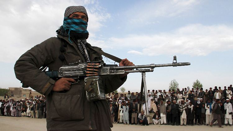 Ein Taliban steht auf diesem Bild aus dem April Wache vor einer Menschenmenge.