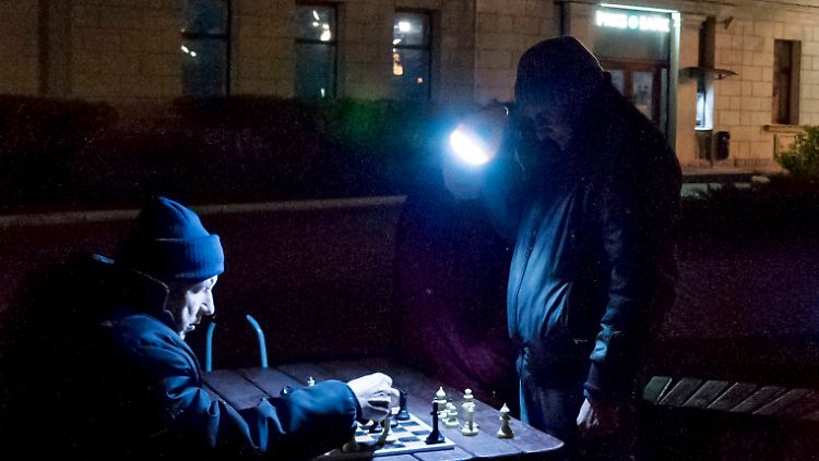 Mit einer Taschenlampe behelfen sich diese beiden Schachspieler in Sewastopol auf der Krim.