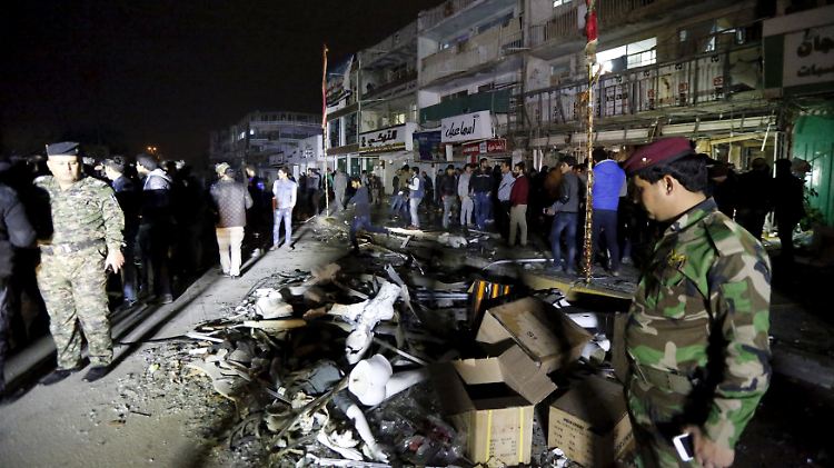 Polizisten sichern die Straße in Bagdad, wo eine Autobombe explodierte.
