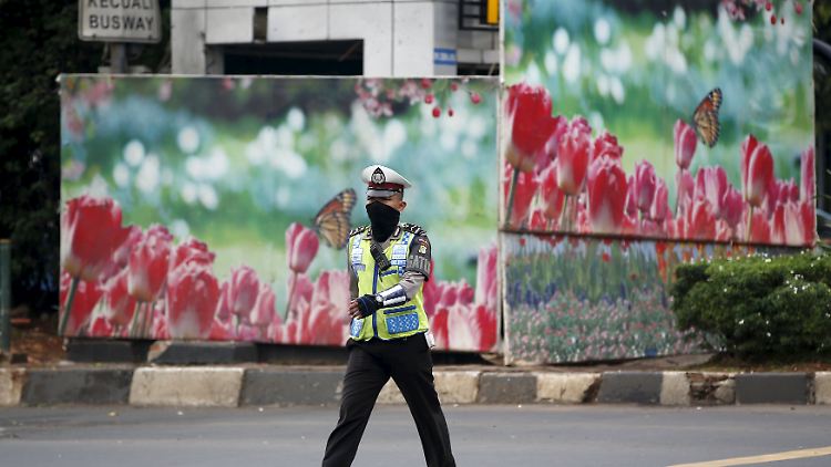 Blumen statt Blut: Bunte Bilder verdecken die zerstörte Polizeiwache in Jakarta. 