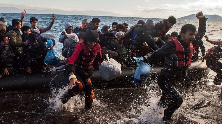 Migranten jubeln nach erfolgreicher Ankunft auf der griechischen Insel Lesbos.