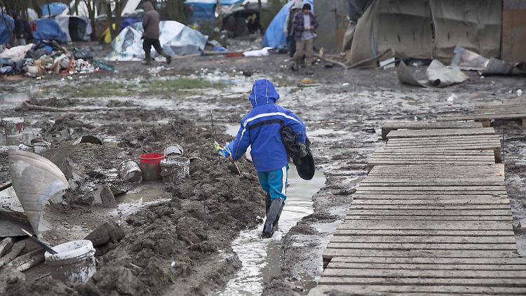Ein Kind watet durch den Matsch in einem Flüchtlingslager in Frankreich.