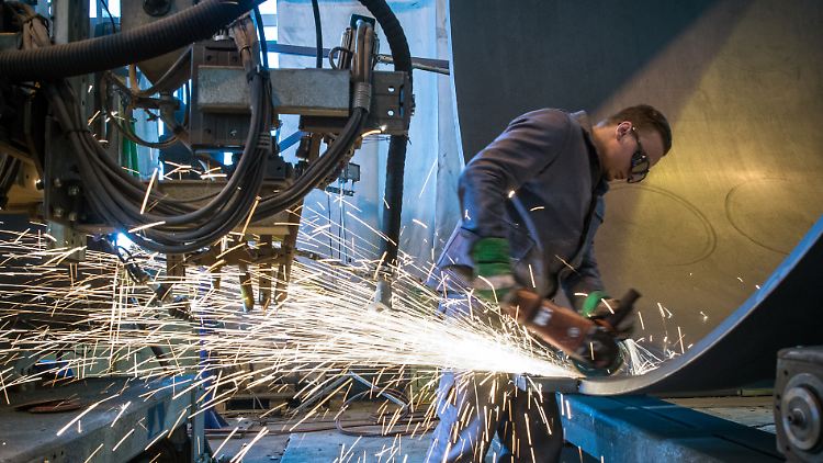 Mit dem Winkelschleifer die Kanten eines Stahlsegments einer Windkraftanlage glätten: Alltagszene aus dem Inneren der deutschen Wirtschaft.