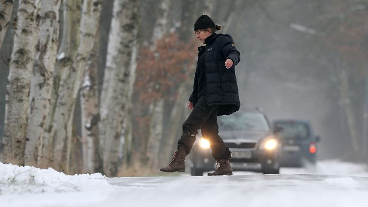Regen auf gefrorenem Boden ergibt vereiste Straßen, die gefährlich für Fußgänger und Autos sind.