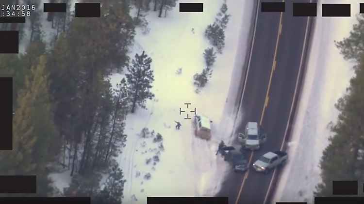 Blutiges Ende im Konflikt mit der Staatsgewalt: Die Straßensperre aus der Luft, Robert "LaVoy" Finicum steht mit erhobenen Armen links neben dem weißen Geländewagen.