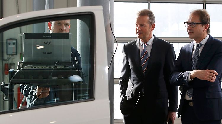 Herbert Diess (l.), Alexander Dobrindt sind dabei, als ein Amarok ein Software-Update erhält.