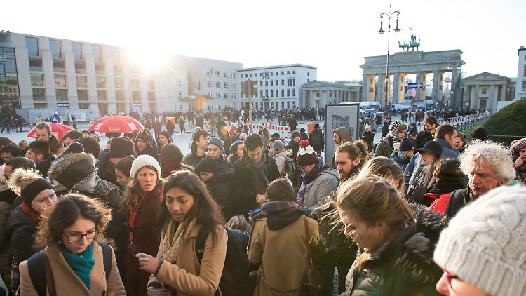Deutsche und ausländische Touristen drängen sich rund um das Brandenburger Tor.