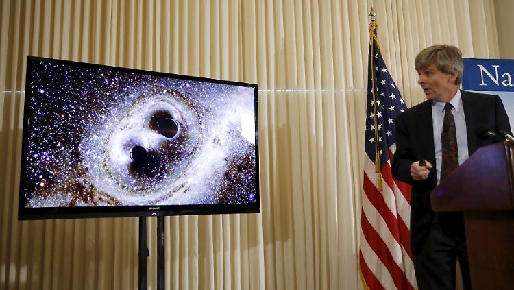 Dieses Ereignis soll Schockwellen durch Raum und Zeit ausgesandt haben: Einer der Ligo-Wissenschaftler führt auf der Bühne den Zusammenstoß zweier Schwarzer Löcher in der Videografik vor.