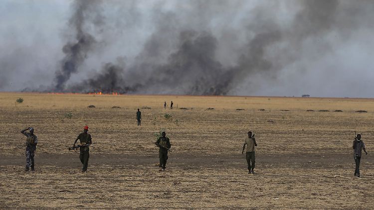 Die Lage im Südsudan ist extrem unübersichtlich - wer für das Massaker an den Zivilisten verantwortlich ist, ist nicht klar. Hier marschieren Rebellensoldaten in breiter Linie vor einem selbst gelegten Buschfeuer.