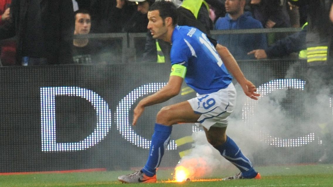 Eklat: Italiens Gianluca Zambrotta flüchtet vor einem feuerwerkskörper.