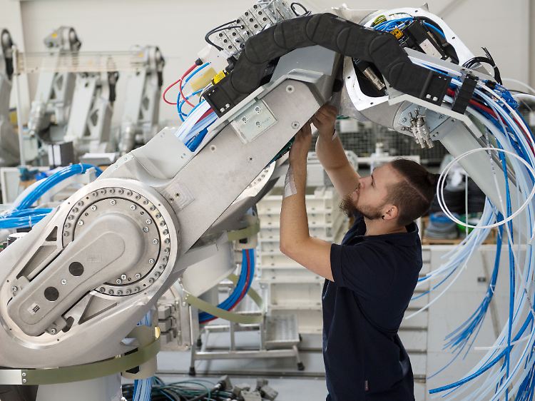 Ein Mitarbeiter der Dürr AG montiert in Bietigheim-Bissingen (Baden-Württemberg) einen Lackierroboter.