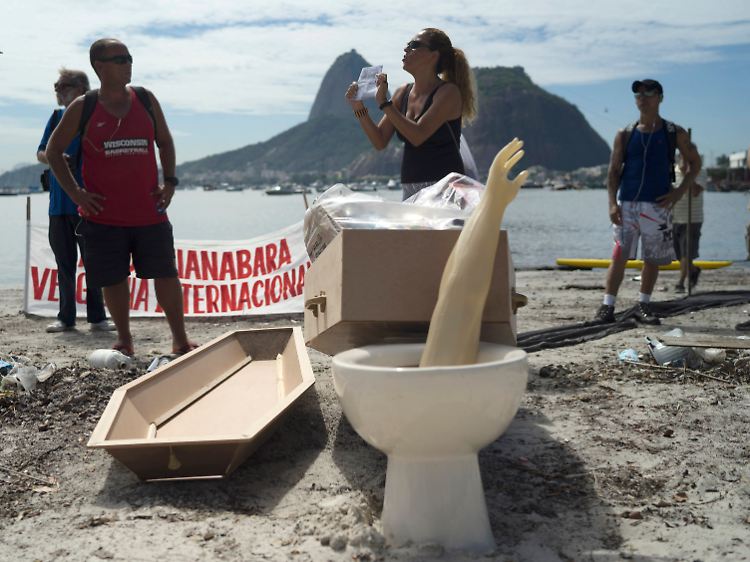 Umweltaktivisten beerdigen am Botafogo-Beach die verdreckte Bucht symbolisch - mit einer Toilettenschüssel, einem amputierten Arm aus Plastik sowie weiterem Müll.
